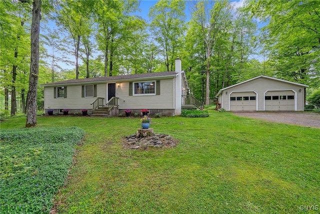 view of front of home with a chimney, a garage, an outbuilding, and a front lawn
