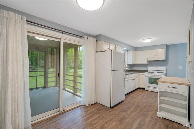 kitchen featuring white appliances, under cabinet range hood, plenty of natural light, and dark wood-type flooring
