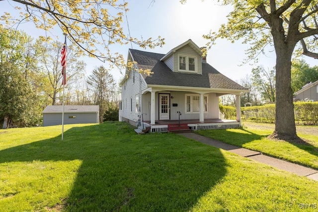 view of front of house featuring covered porch, a front yard, and a shingled roof