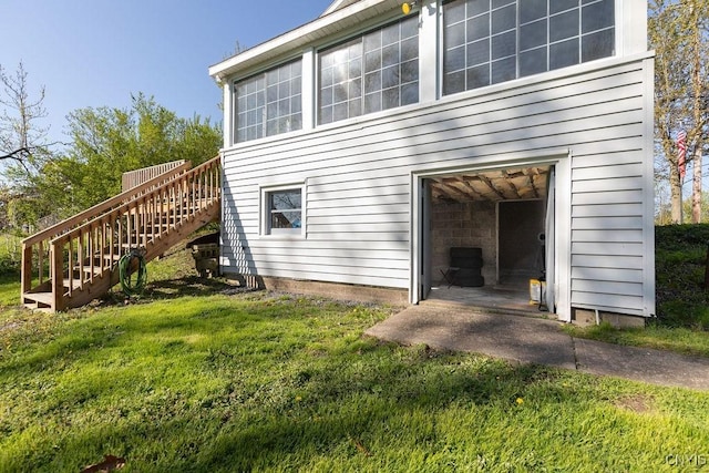 view of home's exterior featuring a lawn and stairway