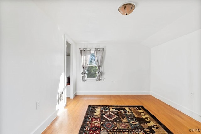 bonus room with light wood-type flooring, baseboards, and vaulted ceiling