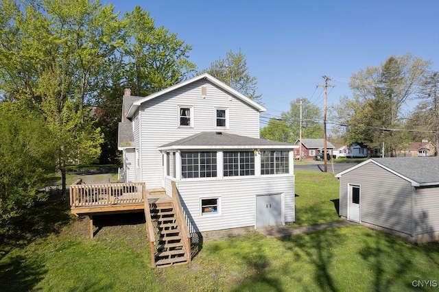 back of house with stairs, a chimney, a sunroom, a deck, and a lawn