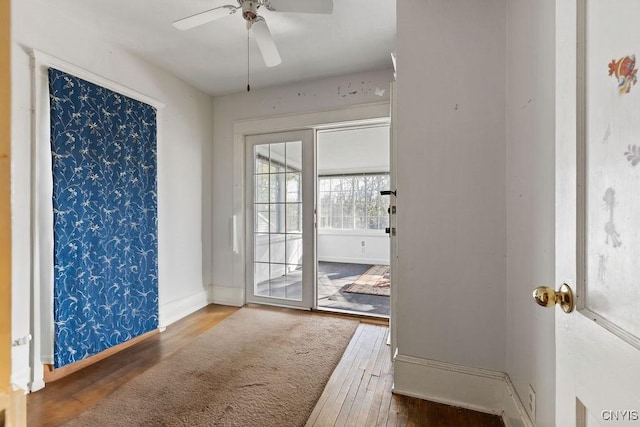 doorway to outside with hardwood / wood-style flooring, a ceiling fan, and baseboards