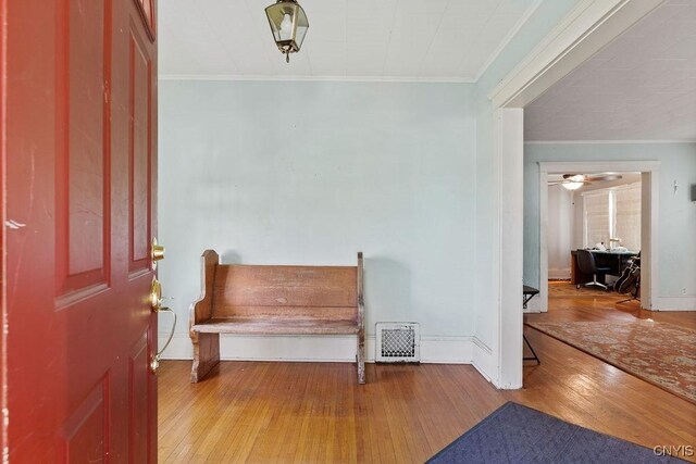 entrance foyer with hardwood / wood-style floors, crown molding, and baseboards