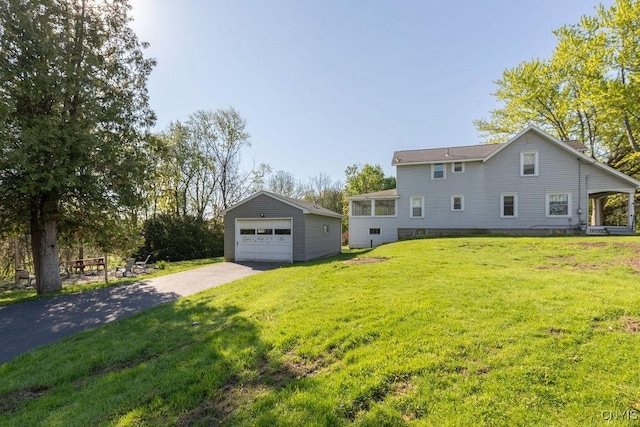 view of home's exterior with an outdoor structure, a garage, driveway, and a yard