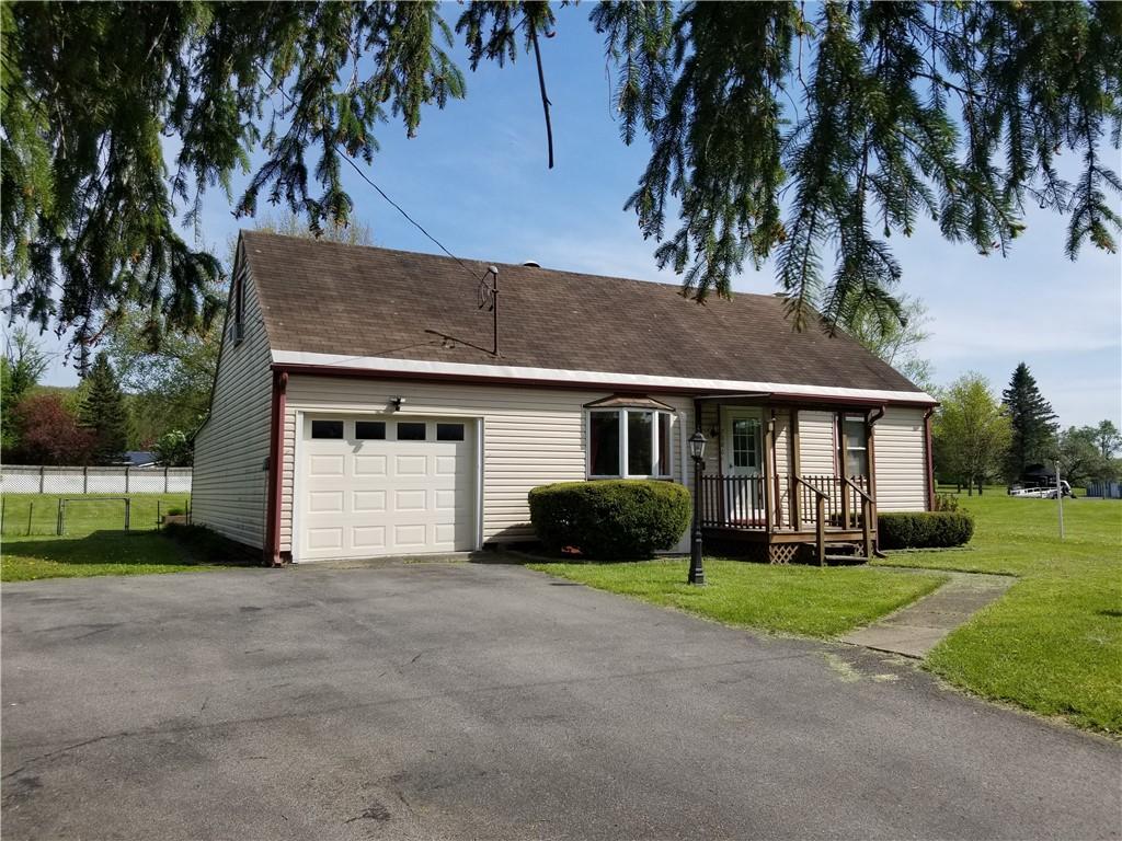 7086 State Highway 12, North Norwich, NY 13815 - single story home featuring a garage, a front yard, asphalt driveway, and covered porch