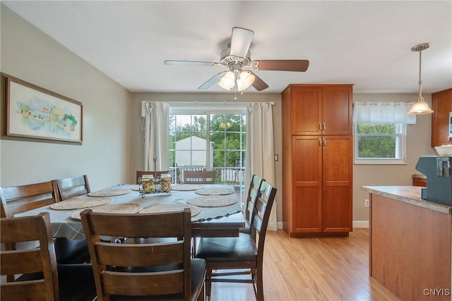 dining room with light wood-type flooring, ceiling fan, and baseboards