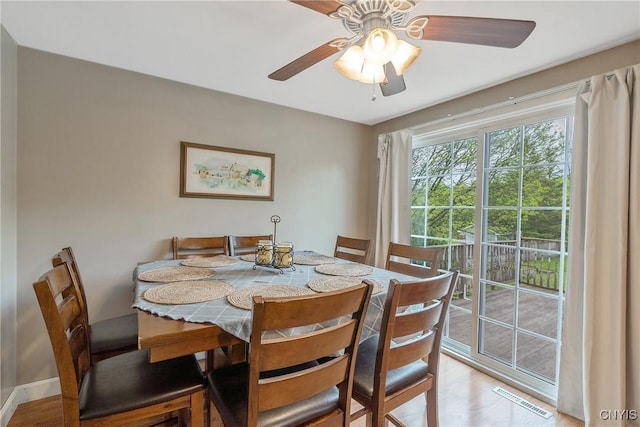 dining space with ceiling fan and light wood-type flooring