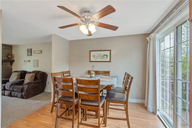 dining area featuring light wood-style floors, baseboards, and ceiling fan