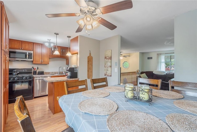 dining room with ceiling fan and light wood-style flooring