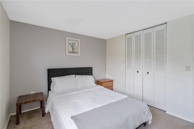 bedroom with light colored carpet, a closet, and baseboards