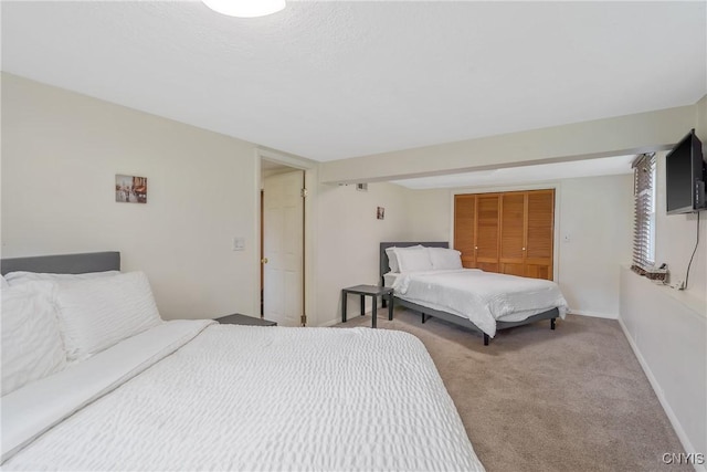 carpeted bedroom featuring baseboards