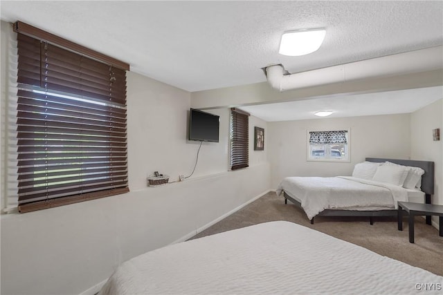 carpeted bedroom with a textured ceiling and baseboards