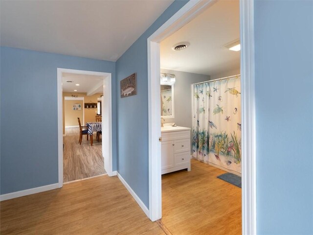 8521 W Buckingham St, Richmond, NY 14471 - full bath with wood finished floors, baseboards, vanity, and a shower with curtain