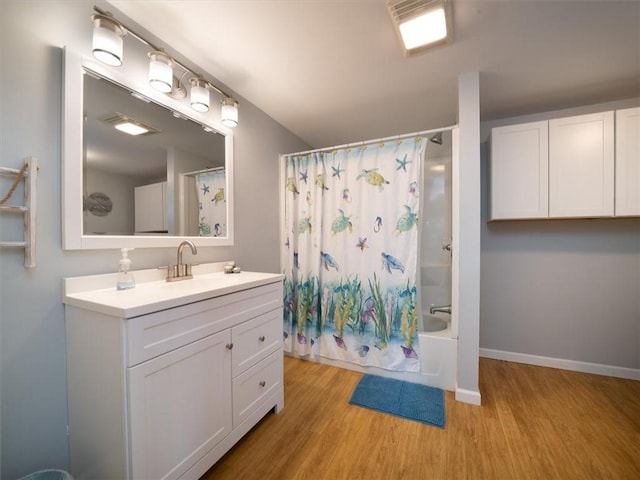 8521 W Buckingham St, Richmond, NY 14471 - full bathroom featuring wood finished floors, shower / bathtub combination with curtain, vanity, and baseboards