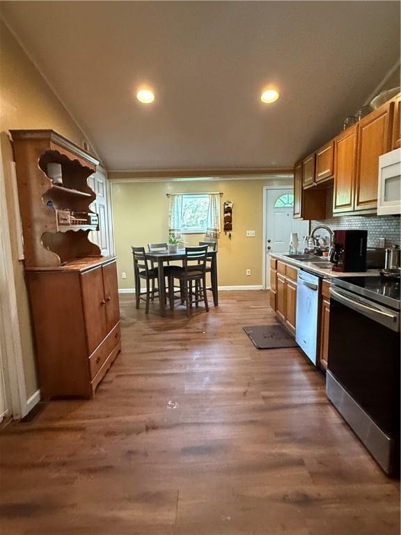 760 Spruce St, Southport, NY 14904 - kitchen with appliances with stainless steel finishes, baseboards, a sink, wood finished floors, and tasteful backsplash