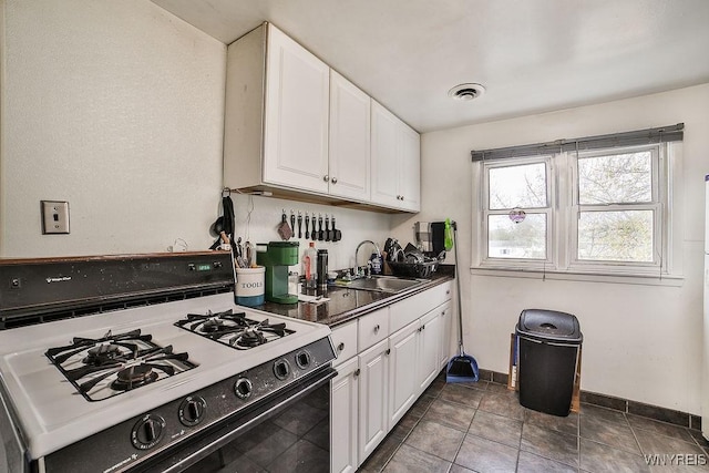 3648 S Park Ave, Hamburg, NY 14219 - kitchen featuring white gas stove, a sink, white cabinetry, baseboards, and dark countertops