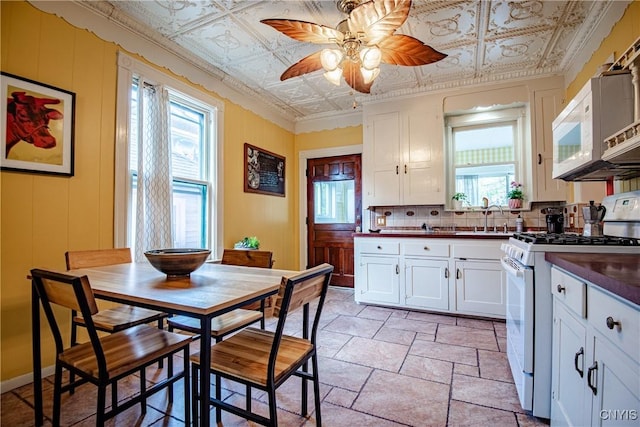 18 Avery Pl, Utica, NY 13502 - kitchen with white appliances, dark countertops, ceiling fan, backsplash, and an ornate ceiling
