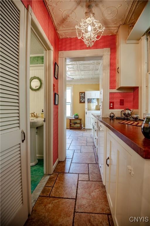 18 Avery Pl, Utica, NY 13502 - corridor featuring stone tile floors, an ornate ceiling, a chandelier, and baseboards