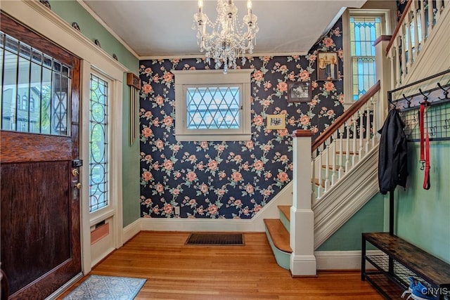 18 Avery Pl, Utica, NY 13502 - foyer entrance with wood finished floors, stairs, a chandelier, healthy amount of natural light, and ornamental molding