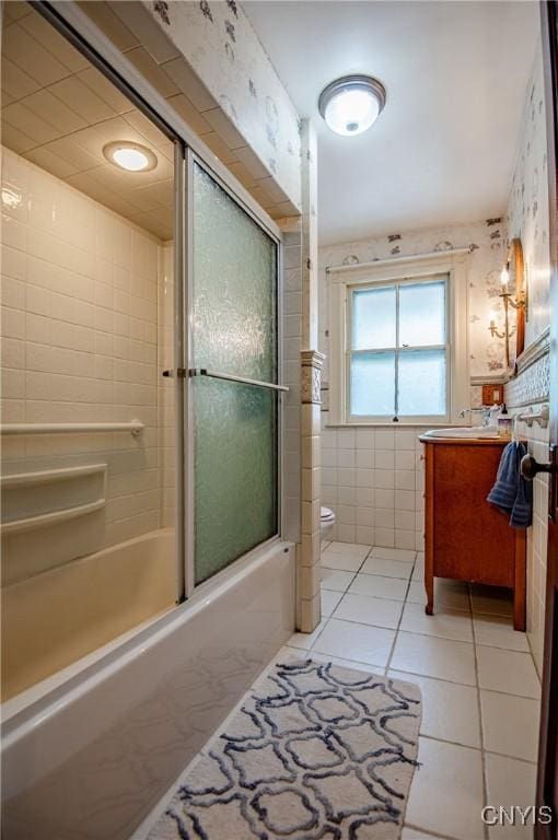 18 Avery Pl, Utica, NY 13502 - bathroom with vanity, tile patterned floors, toilet, shower / bath combination with glass door, and tile walls