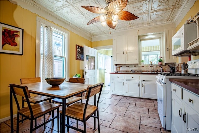 18 Avery Pl, Utica, NY 13502 - kitchen with white appliances, dark countertops, ceiling fan, an ornate ceiling, and backsplash