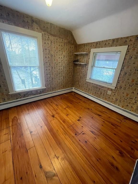 211 Main St, Delhi, NY 13753 - empty room with lofted ceiling, wood-type flooring, baseboards, a baseboard radiator, and wallpapered walls