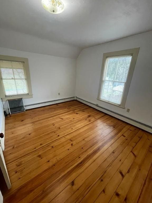 211 Main St, Delhi, NY 13753 - additional living space featuring plenty of natural light, lofted ceiling, a baseboard radiator, and hardwood / wood-style flooring