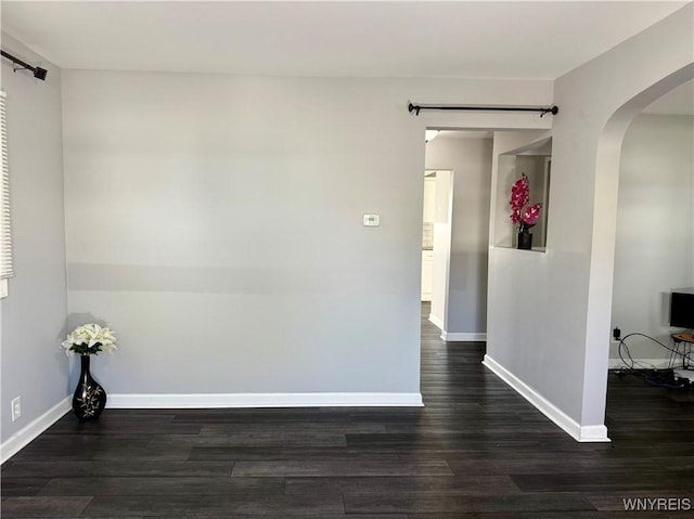 101 Spruce St, Lackawanna, NY 14218 - unfurnished room featuring arched walkways, wood finished floors, baseboards, and a barn door