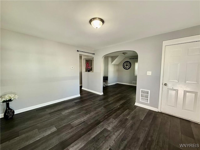 101 Spruce St, Lackawanna, NY 14218 - empty room with arched walkways, dark wood-style flooring, and baseboards
