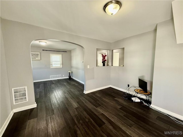 101 Spruce St, Lackawanna, NY 14218 - unfurnished living room with arched walkways, dark wood-style flooring, and baseboards