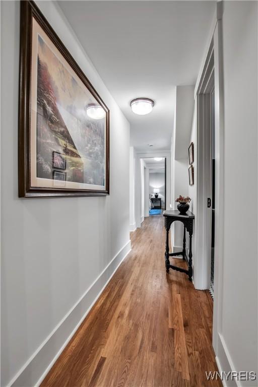 hall with wood finished floors and baseboards
