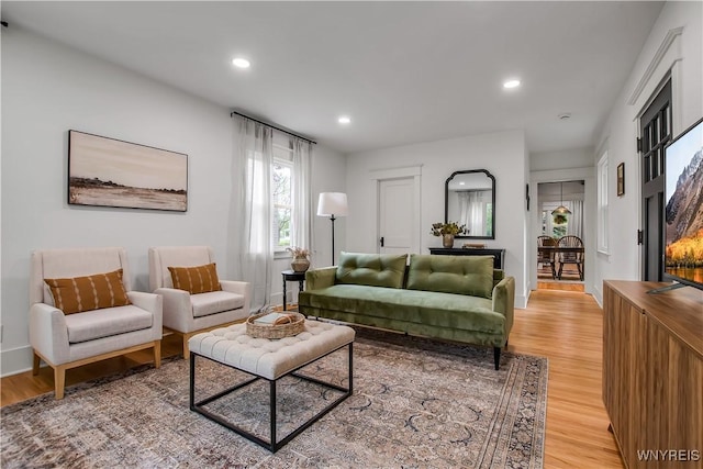 living room with light wood-style floors, recessed lighting, and baseboards