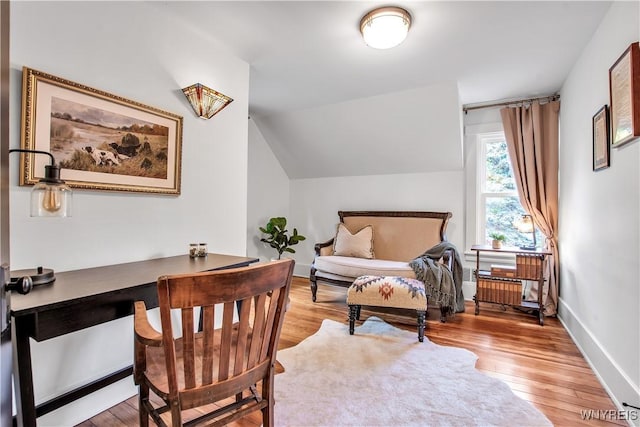 home office with light wood finished floors, vaulted ceiling, and baseboards