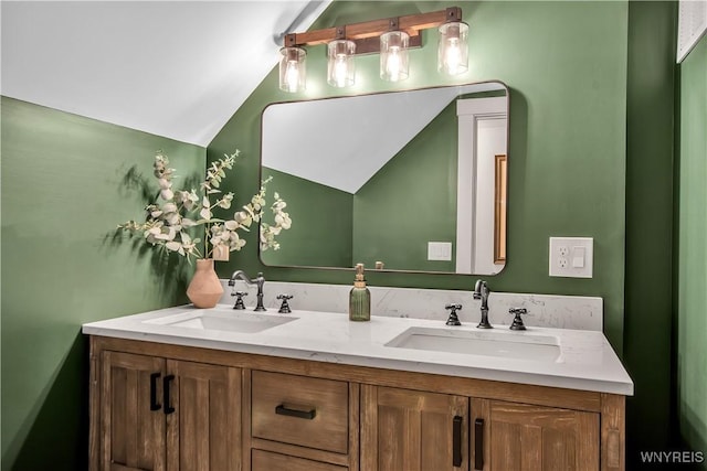 bathroom featuring lofted ceiling and double vanity