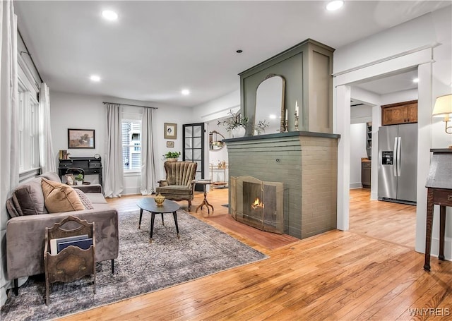 living room with light wood finished floors, a fireplace, and recessed lighting