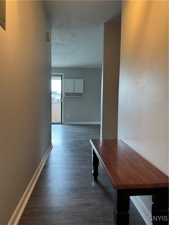 corridor featuring dark wood-style floors and baseboards