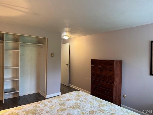 bedroom featuring dark wood-type flooring, a closet, and baseboards