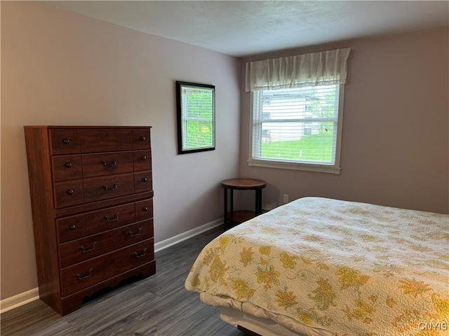 bedroom with dark wood finished floors and baseboards