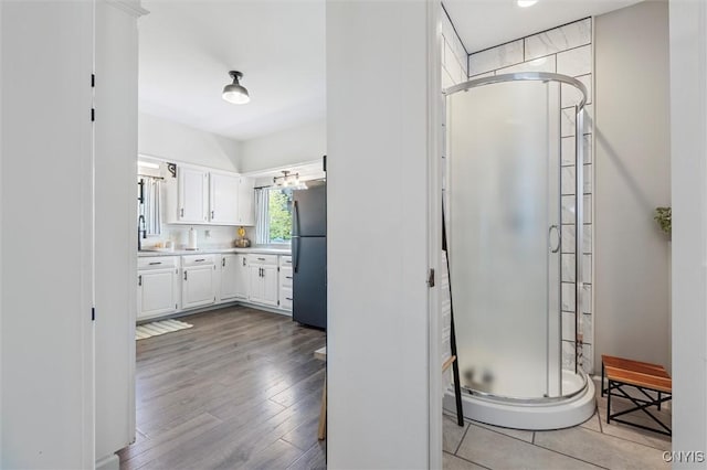 bathroom with a shower stall, vanity, and wood finished floors