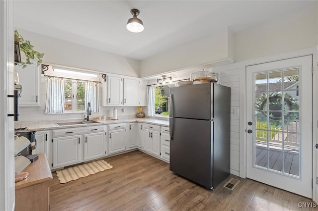 kitchen featuring freestanding refrigerator, a sink, and healthy amount of natural light