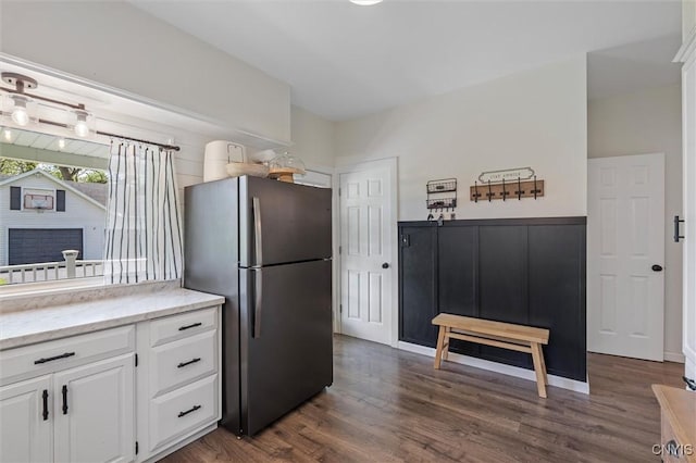 kitchen with freestanding refrigerator, dark wood-type flooring, white cabinetry, and light stone countertops