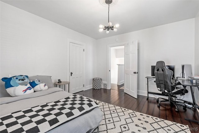 bedroom with dark wood finished floors, a chandelier, baseboards, and an office area