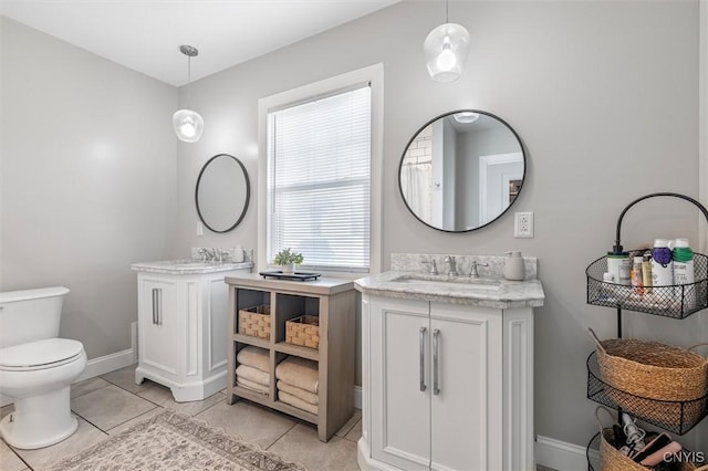 full bathroom featuring two vanities, toilet, baseboards, and tile patterned floors