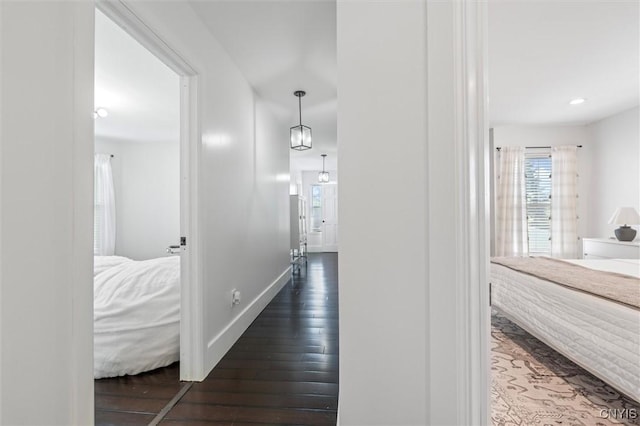 corridor with wood-type flooring, baseboards, and recessed lighting
