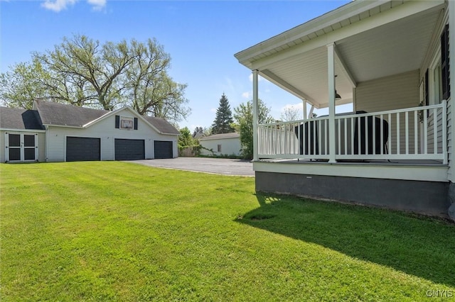 view of grassy yard featuring an outbuilding and a garage