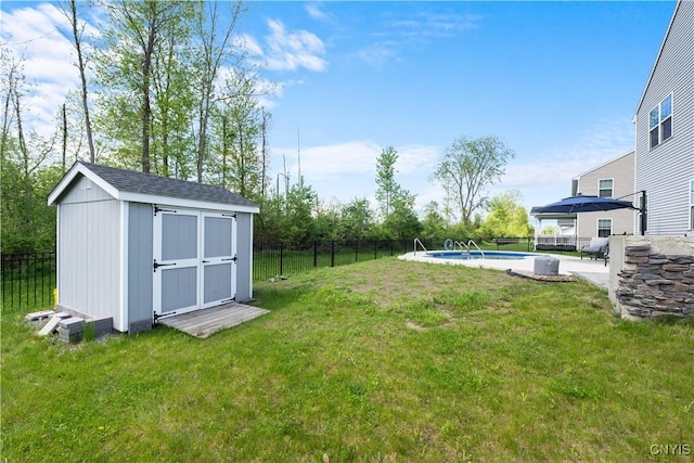 view of yard with a shed, an outdoor structure, and a patio area