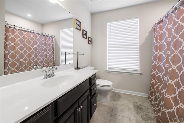 bathroom featuring baseboards, vanity, toilet, and tile patterned flooring
