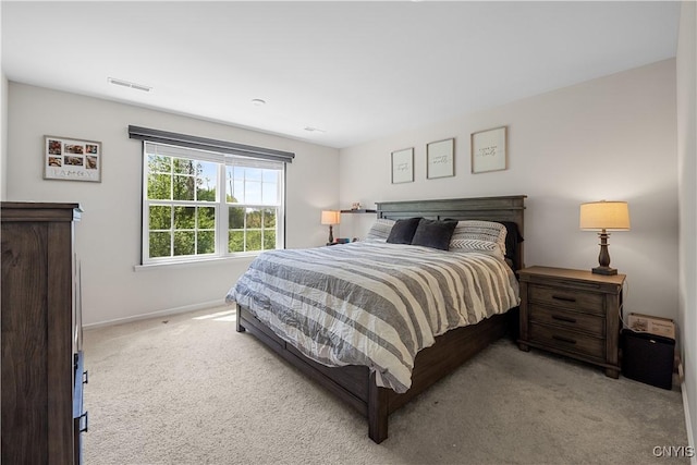 bedroom with light carpet and baseboards