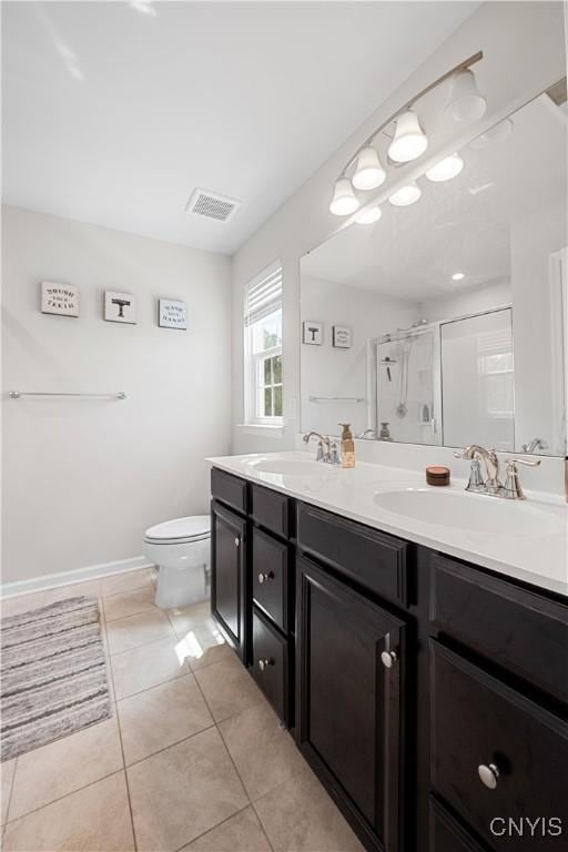 full bathroom with a stall shower, double vanity, toilet, tile patterned floors, and baseboards